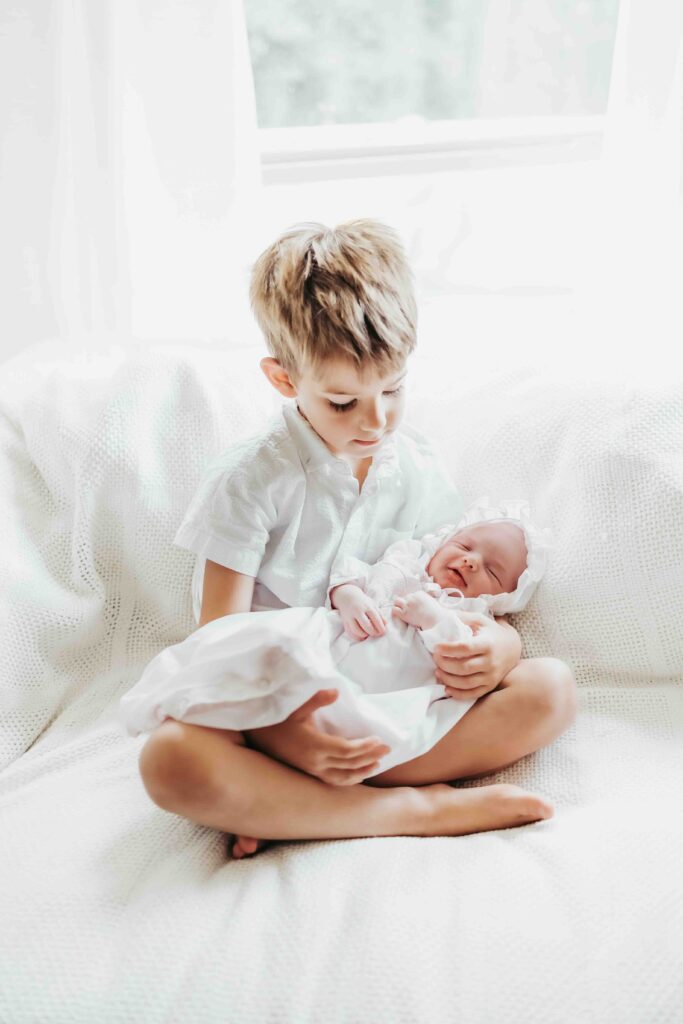youngest brother holds his newborn sister in covington louisiana