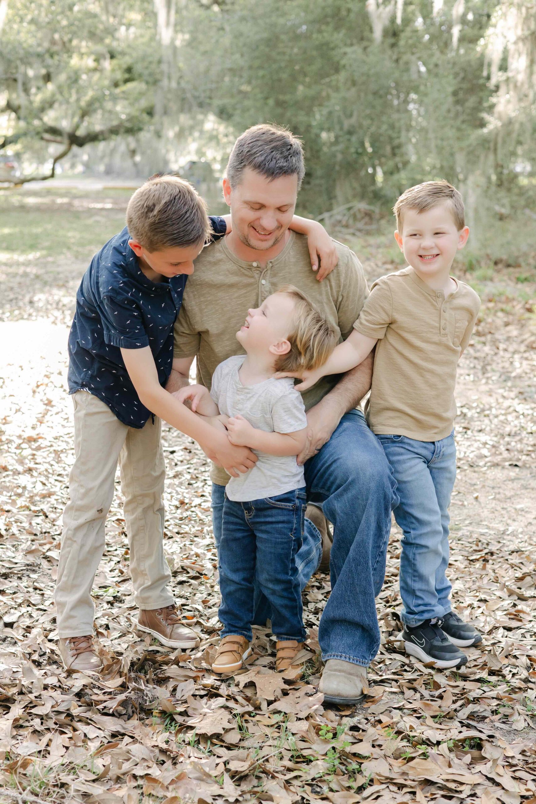 a father interacts with his three sons while captured by their family photographer in mandeville louisiana