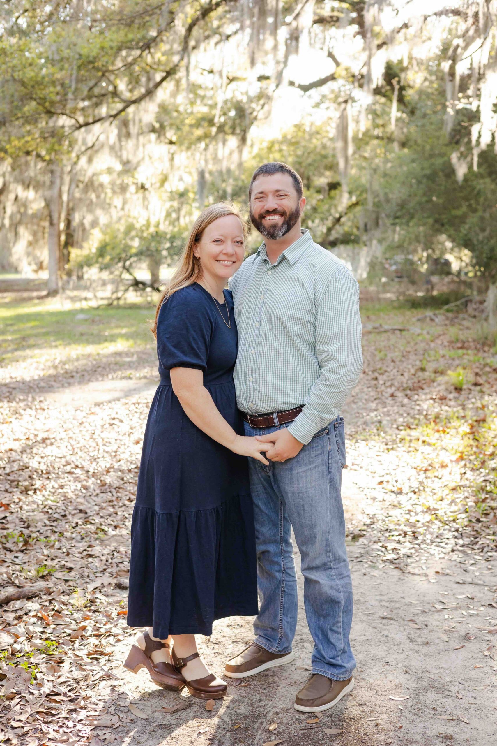 a couple holds hands and smiles for their family photographer in mandeville louisiana