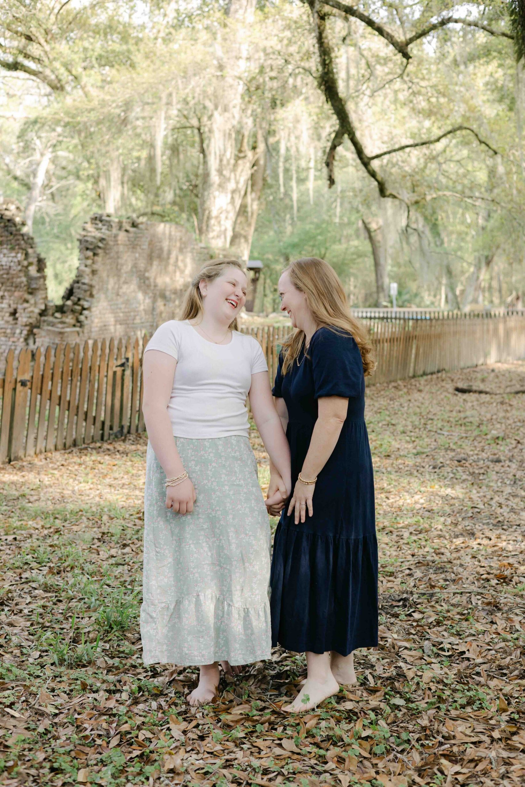 a mother and daughter smile at each other while captured by their family photographer in mandeville louisiana